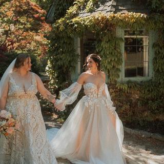 Couple taking wedding photos by a ivy covered cottage