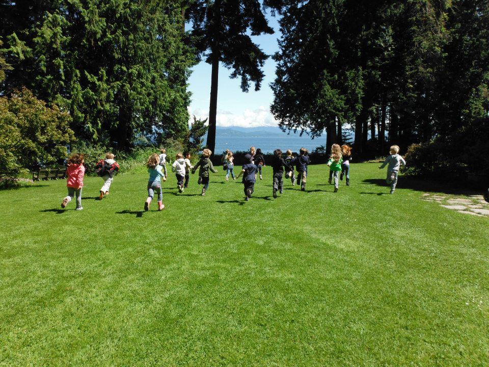 children running towards the ocean on a lawn